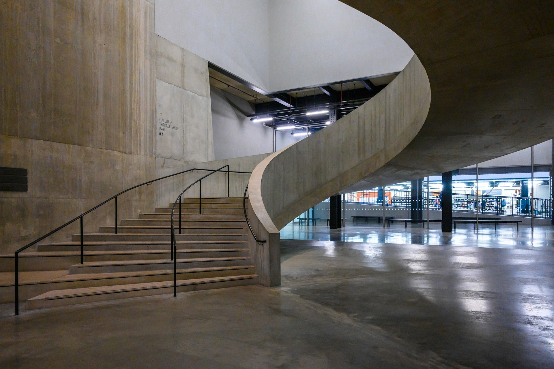 Modern interior with a concrete spiral staircase and adjacent steps. | Photo by the blowup on Unsplash