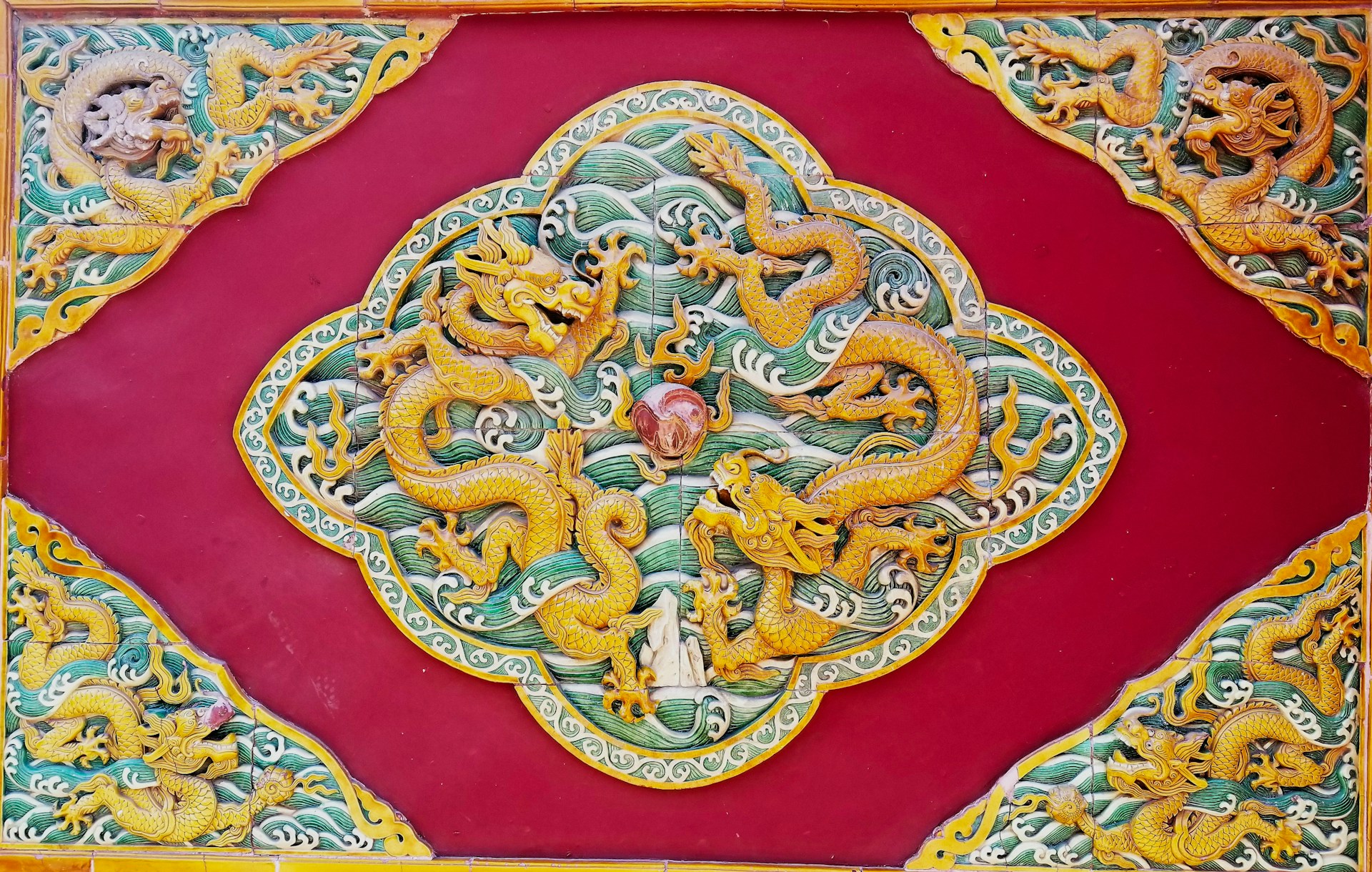 Intricate Chinese dragon relief on red background. | Photo by Emmanuel Appiah on Unsplash