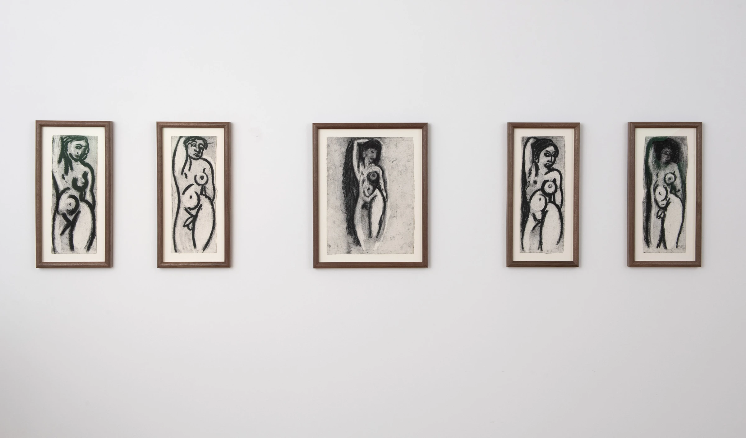 Four framed black-and-white artworks of abstract female figures line a white wall, showcasing bold lines and curvaceous forms.