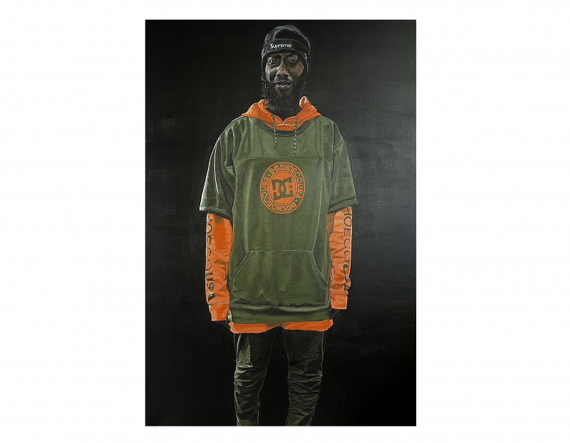 A figure dressed in a green oversized hoodie with orange accents, paired with matching green pants, against a dark background.