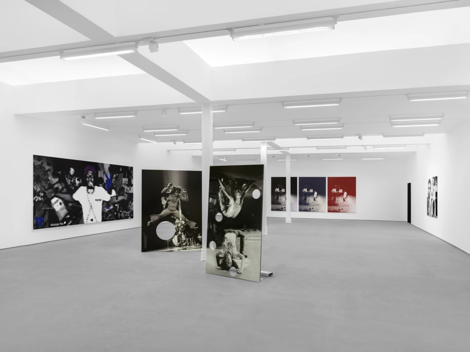 A room featuring several framed pictures hanging on the walls, with a spacious ceiling and floor, resembling an art gallery or exhibition space.