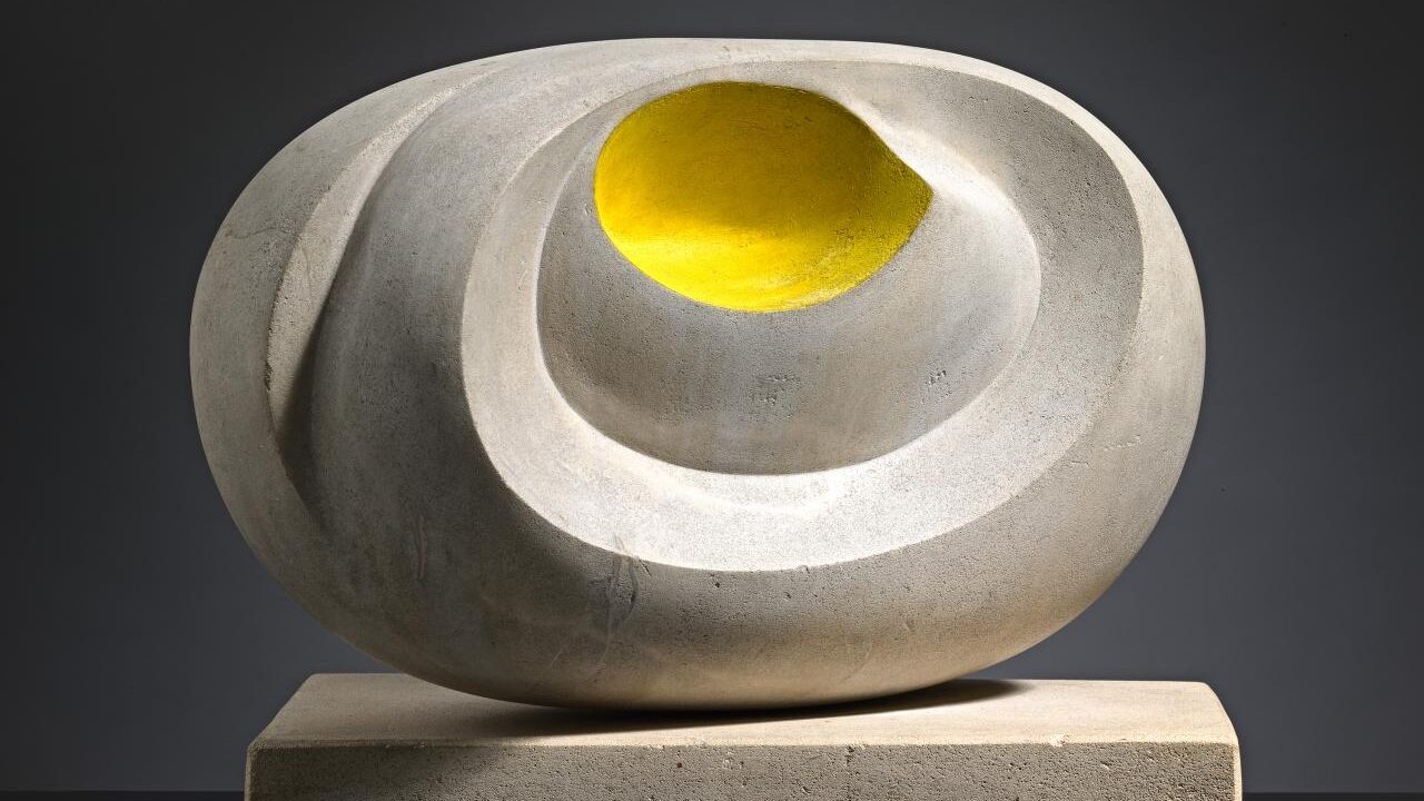 A sculpture featuring a white and yellow ceramic object, resembling a vase or artifact.