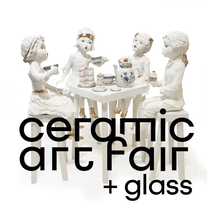 Ceramic art fair + glass with four porcelain dolls seated at a table with a tea set.